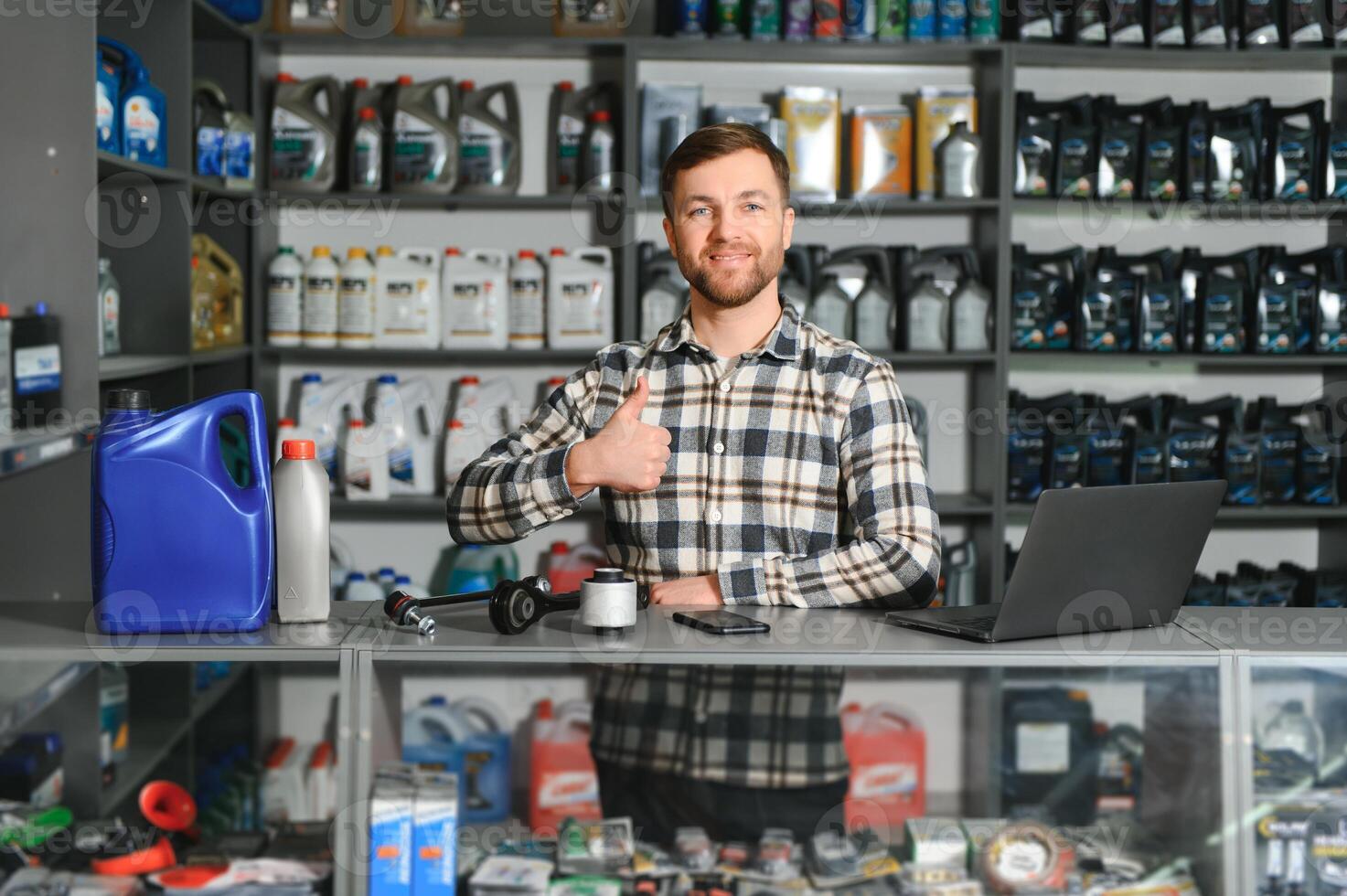 A salesman in an auto parts store. Retail trade of auto parts photo