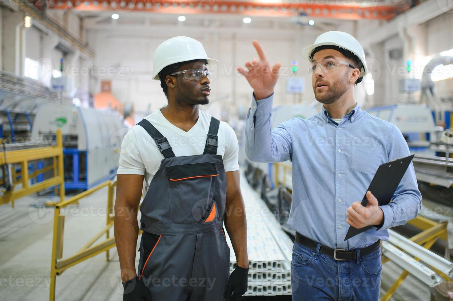 Two workers at a factory for the production of plastic windows. Engineer and worker on the production line photo