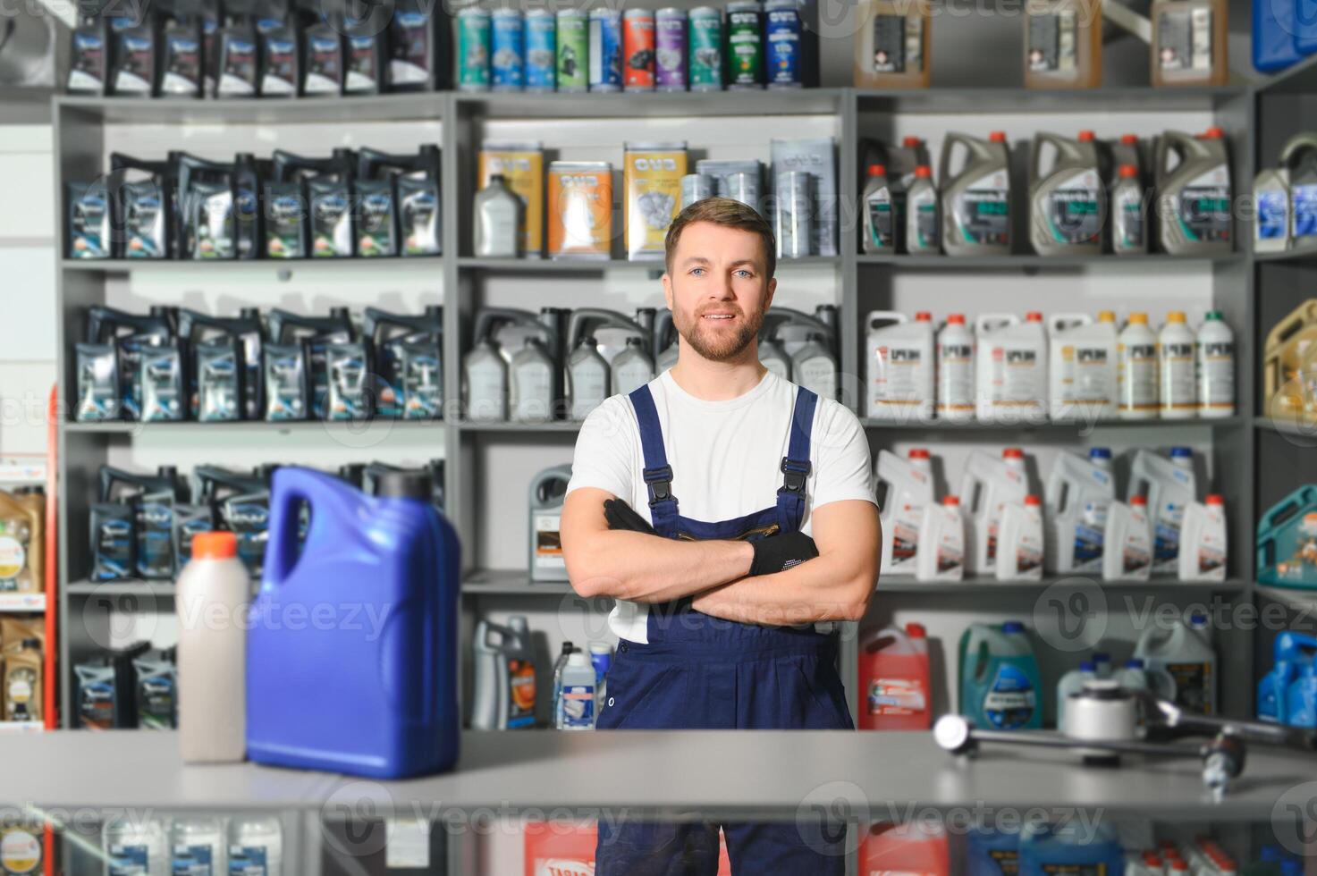 seller man with canister of motor oil in auto store photo