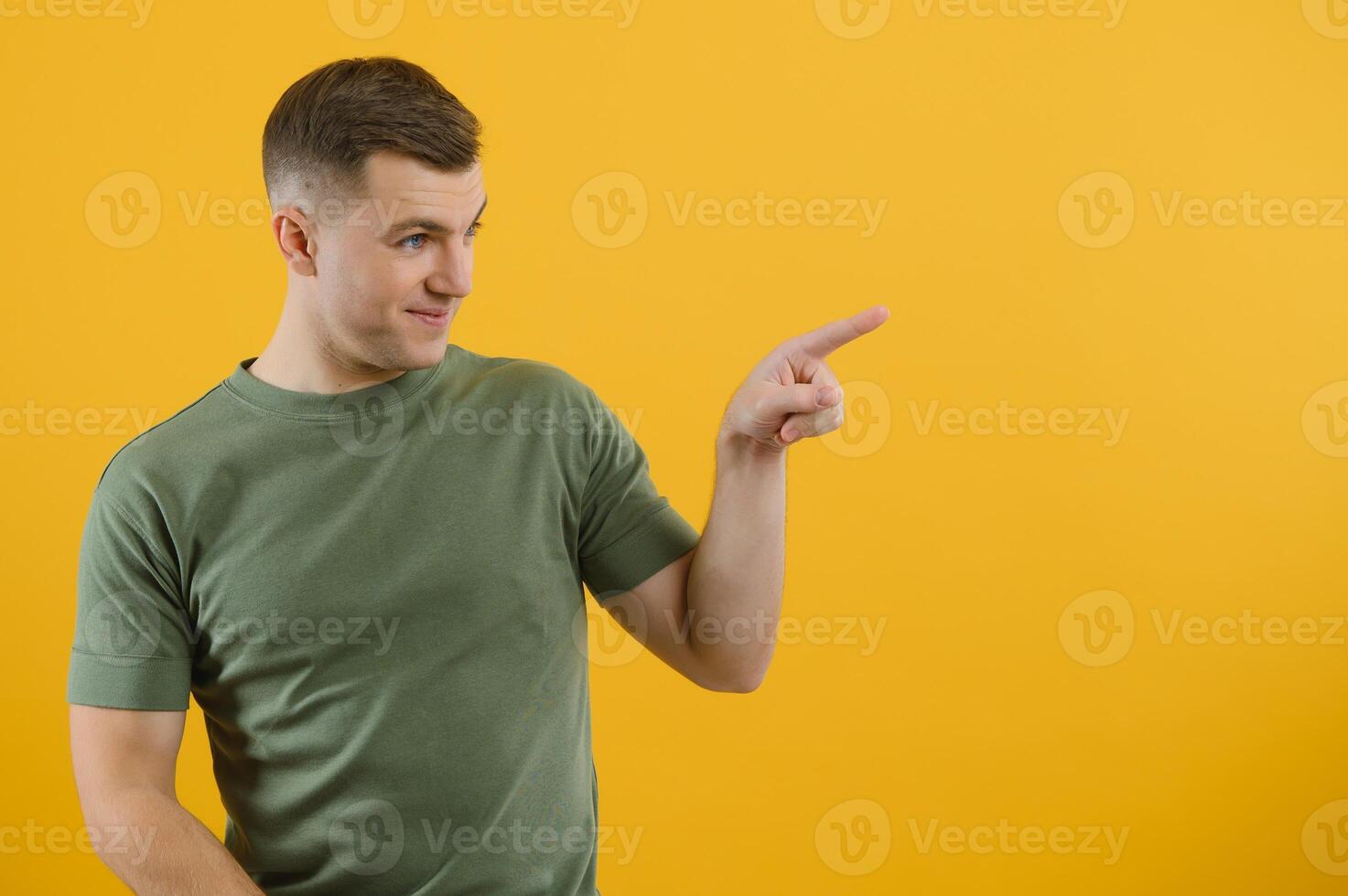 Wow, look at ads here Portrait of surprised shocked man pointing aside, showing blank copy space for idea presentation, commercial text. indoor studio shot isolated on yellow background. photo