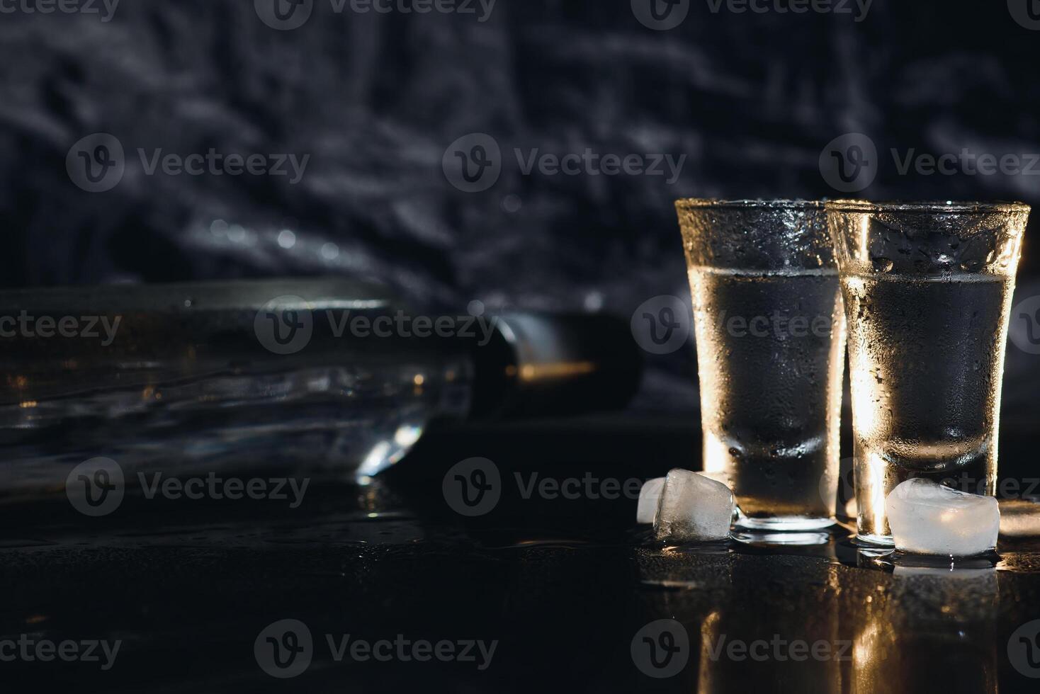 Vodka in shot glasses on dark background photo