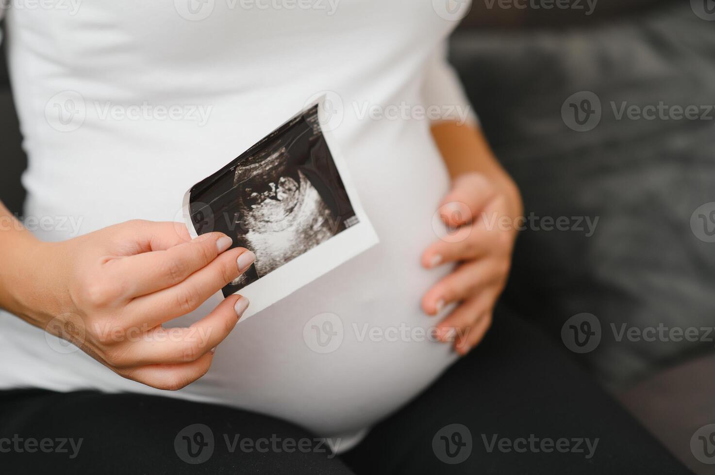 Pregnant women holding echo pictures in hand photo