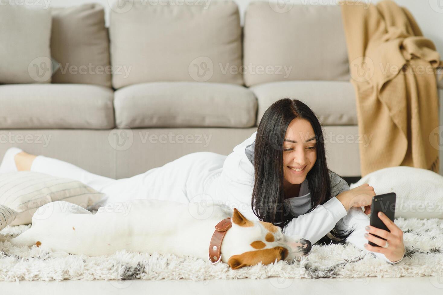 Young woman with her cute dog at home. Lovely pet. photo