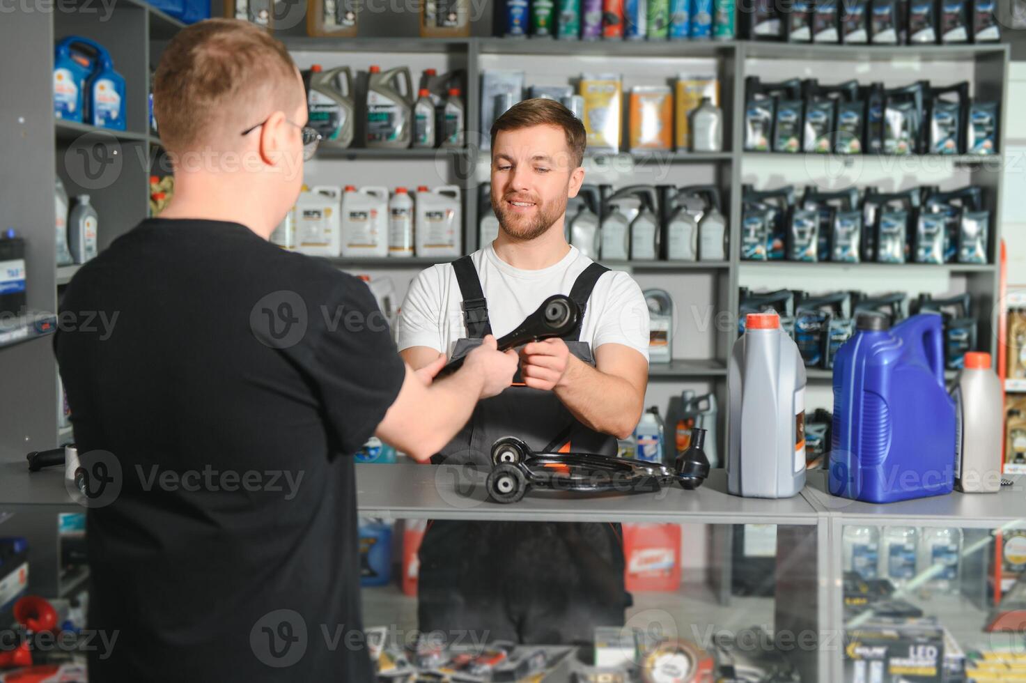 A customer speaks with a consultant at an auto parts store photo