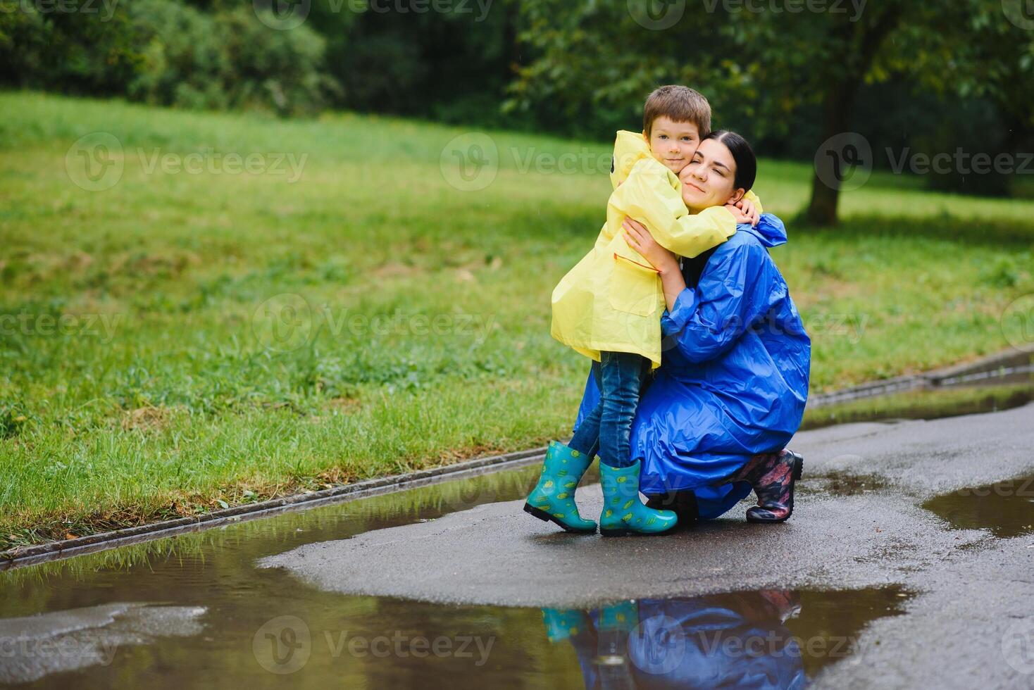 Mother with son walking in the rain under the umbrella photo