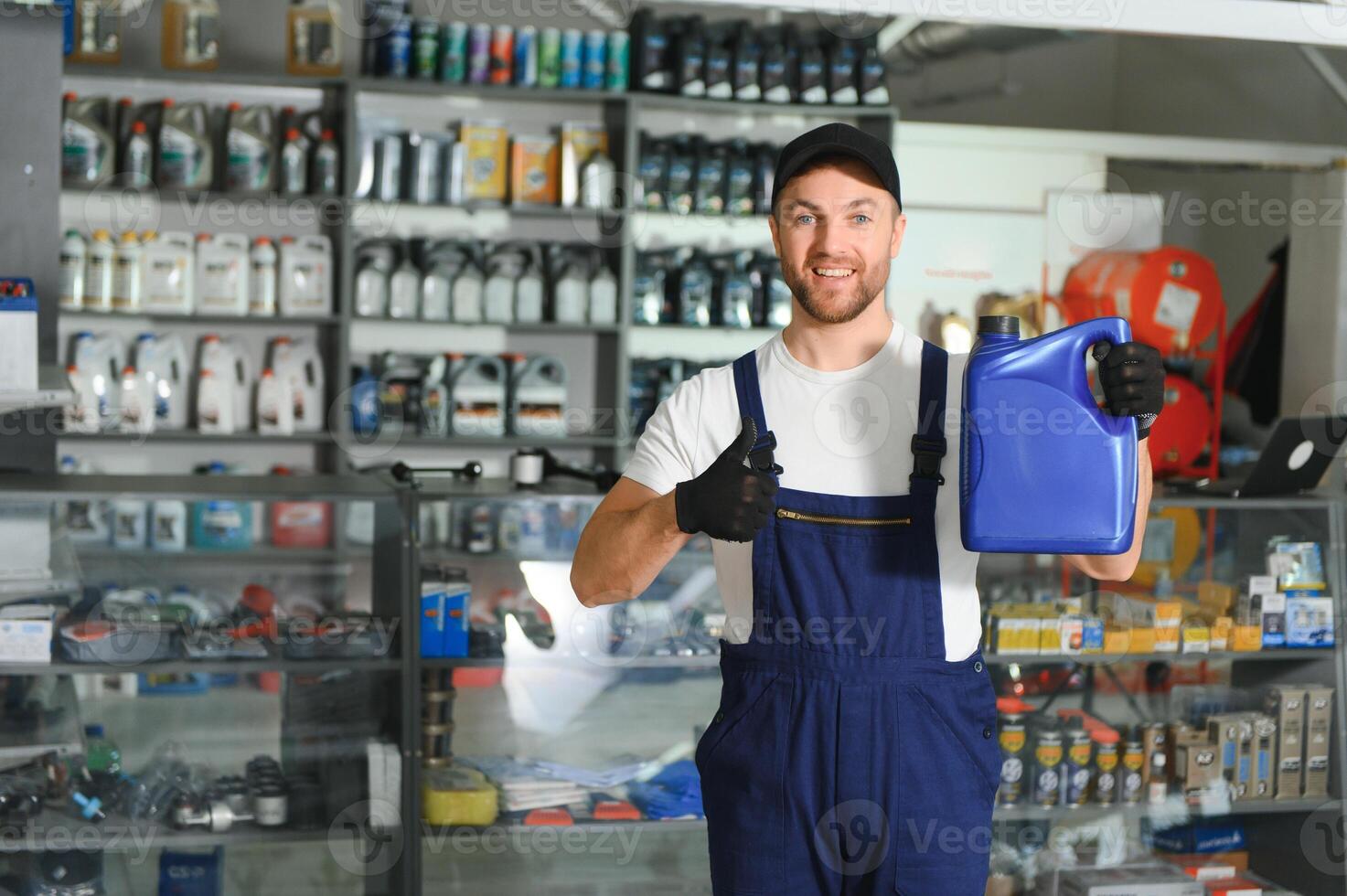 seller man with canister of motor oil in auto store photo