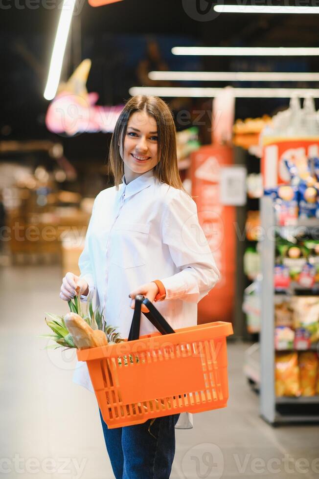 casual mujer tienda de comestibles compras y mirando contento foto