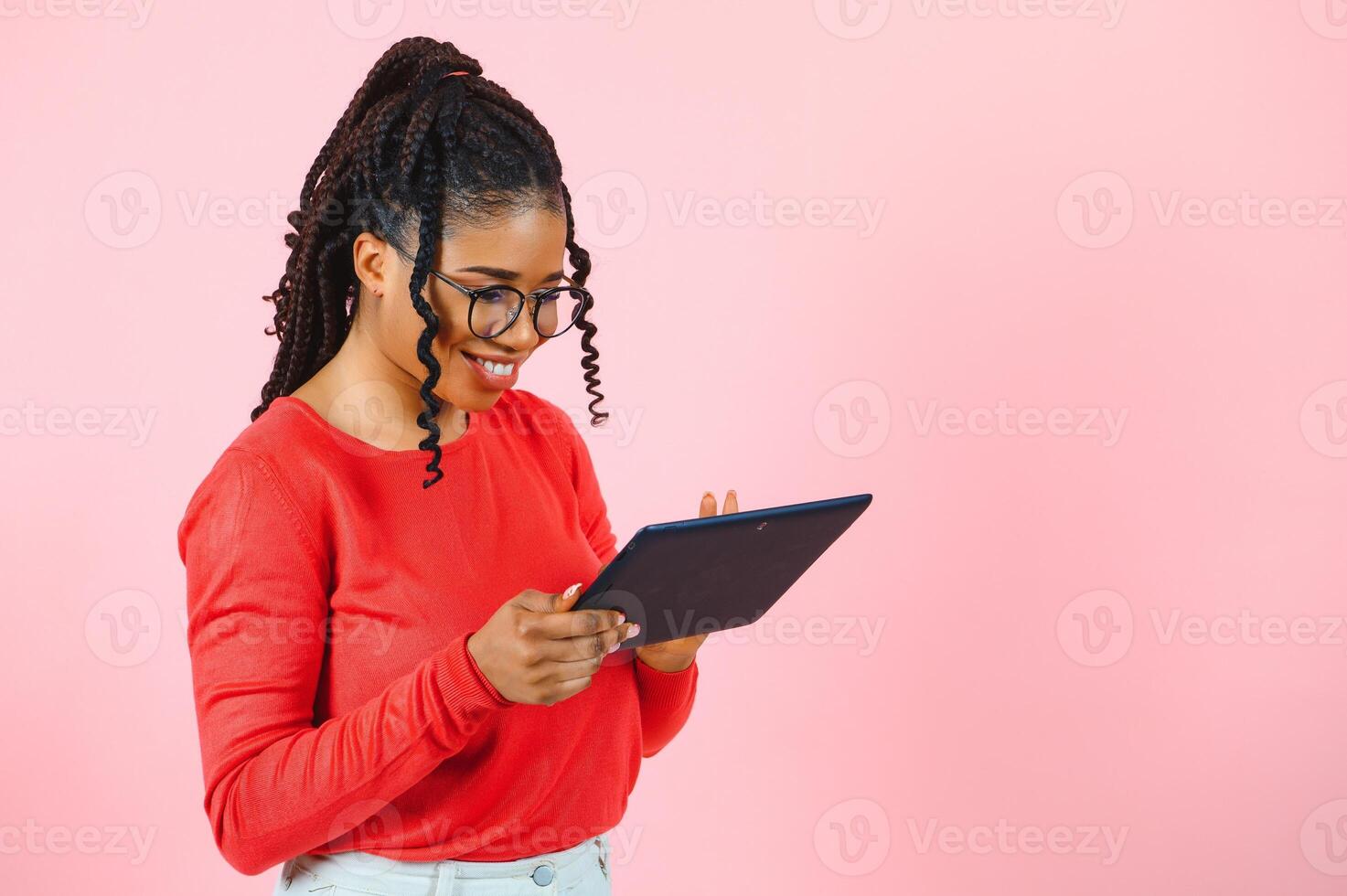 Cool gadget. Interested girl using digital tablet on pink background. photo