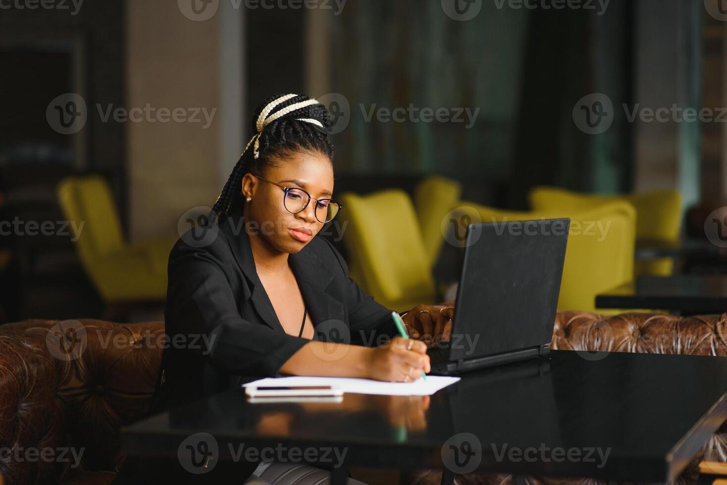 Young African American woman siting at cafe working on laptop photo