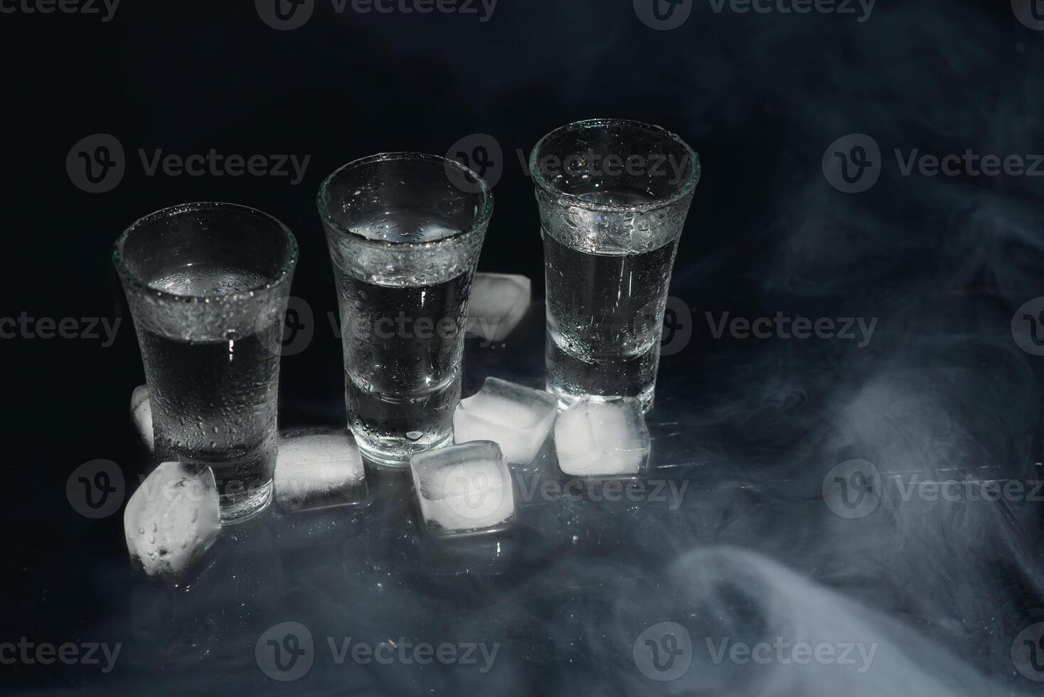 vodka. tiros, lentes con vodka con hielo .oscuro antecedentes. Copiar espacio .selectivo enfocar. foto