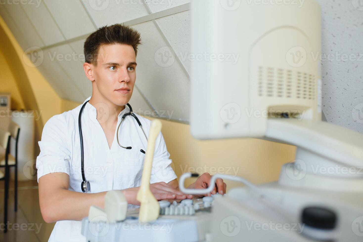 Sonographer operating modern ultrasound machine in clinic photo