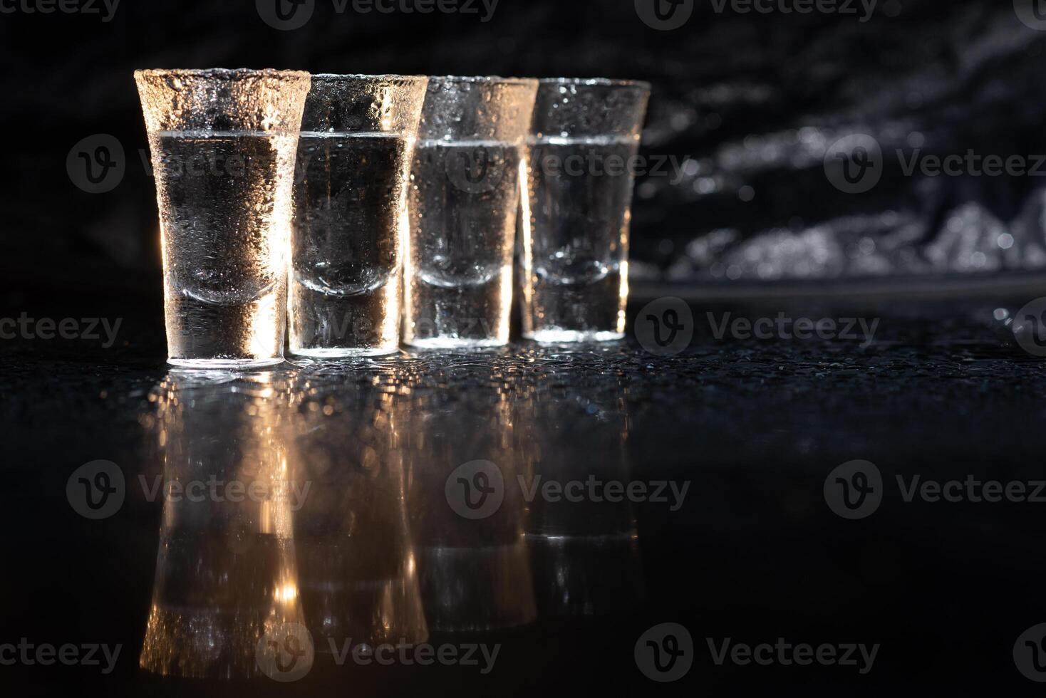 Vodka. Shots, glasses with vodka with ice .Dark background. Copy space .Selective focus. photo