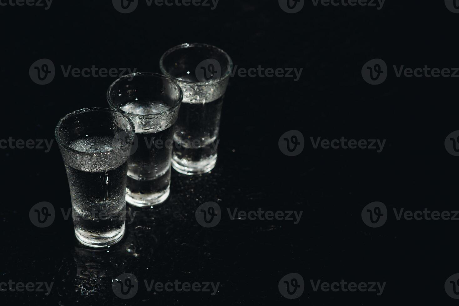 Vodka. Shots, glasses with vodka with ice .Dark background. Copy space .Selective focus. photo