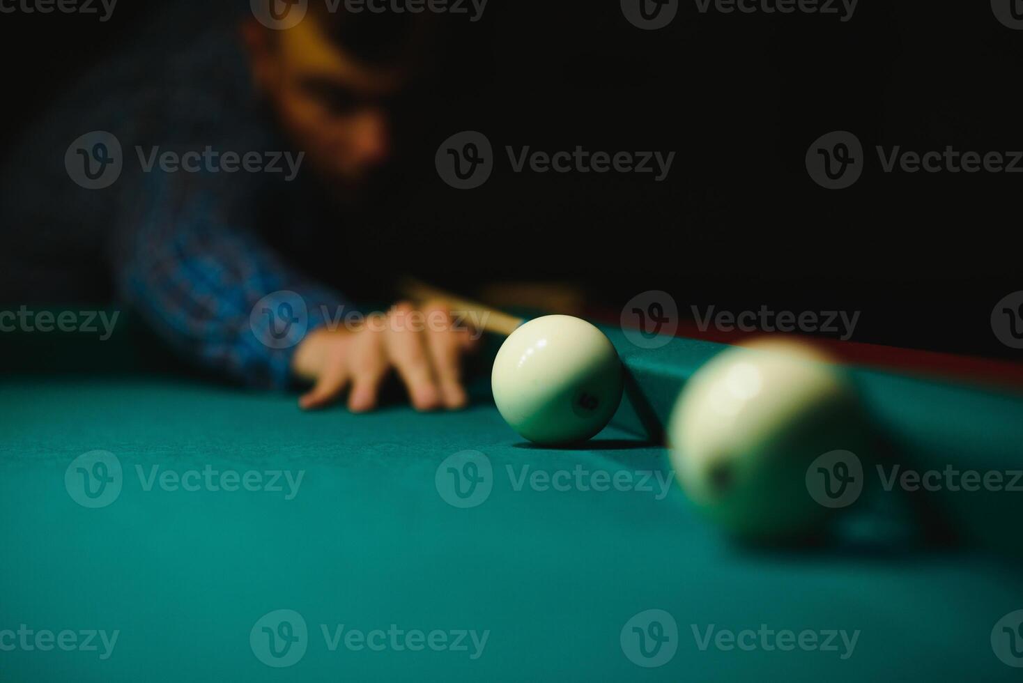 Young man playing billiard. Spending free time on gambling photo