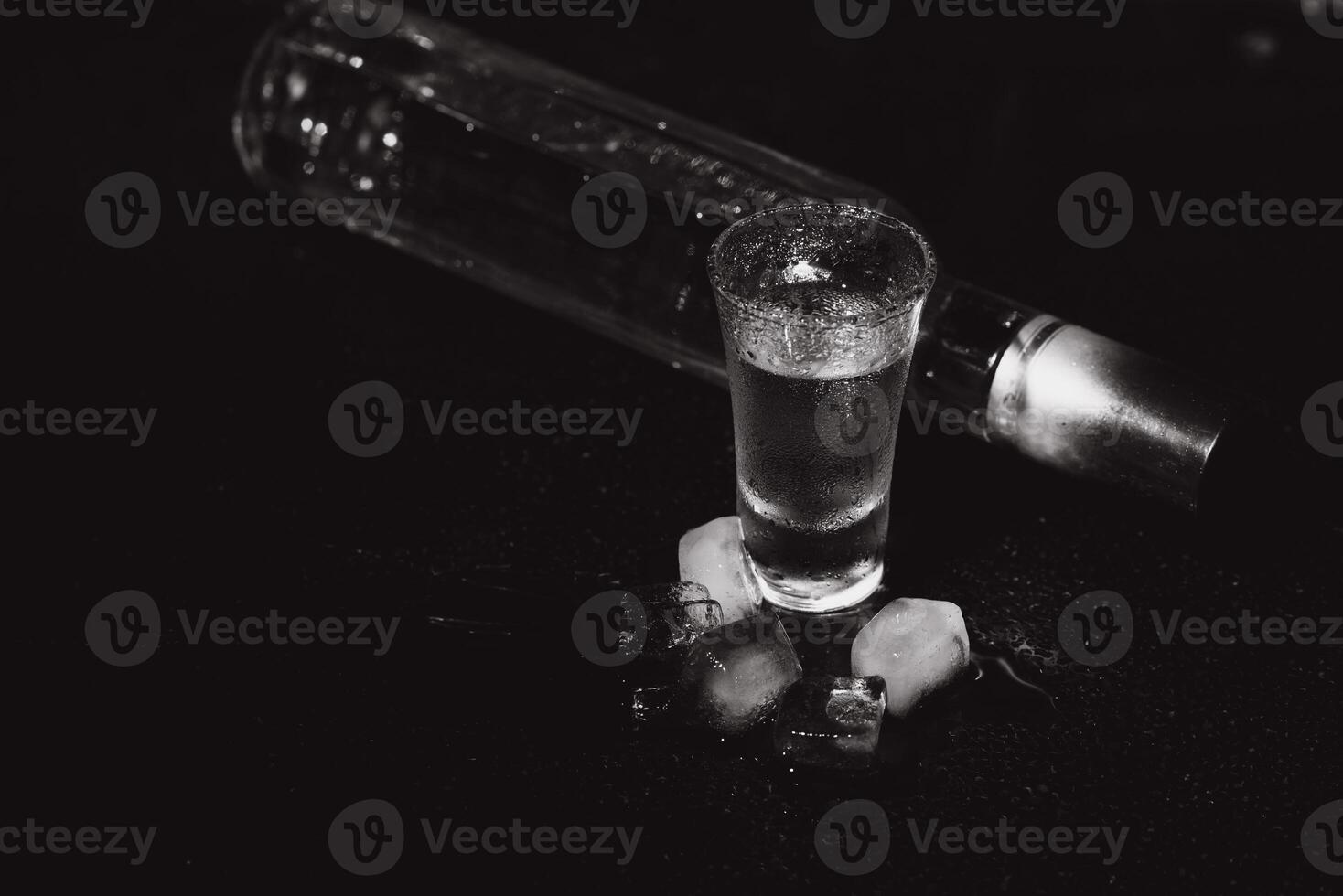 Cold vodka in shot glasses on a black background. Top view. Food background. photo