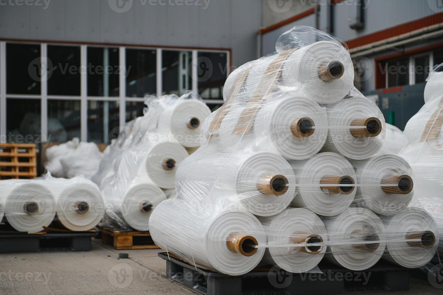 Raw materials warehouse. Many large coils of finished propylene hose made of woven thread for making industrial bags. Polypropylene rolls for packaging. photo