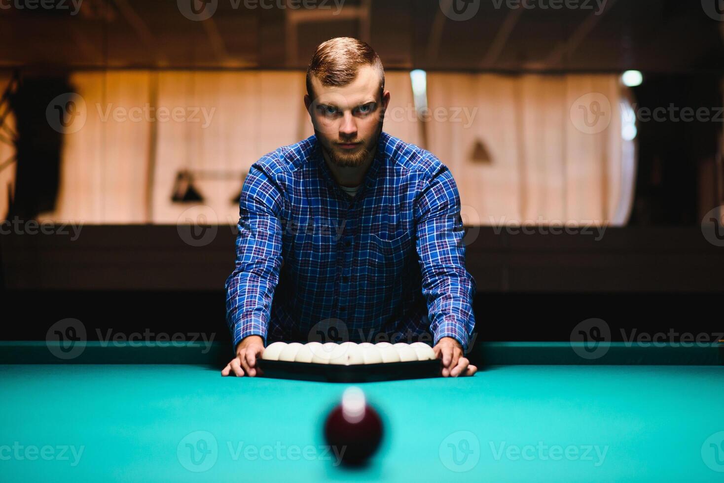 Young man playing billiard. Spending free time on gambling photo