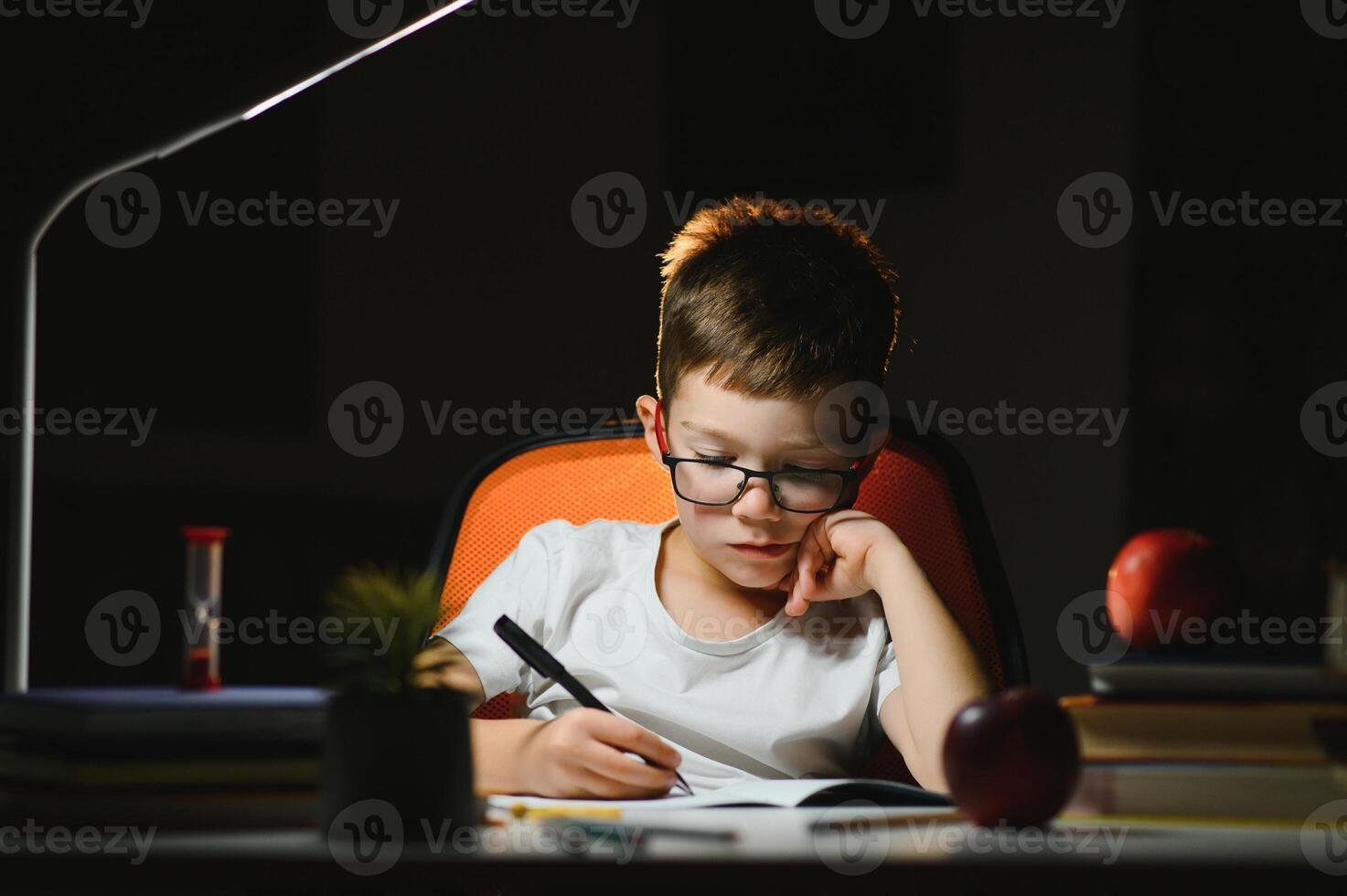 Little boy painting in a dark room late in the evening photo