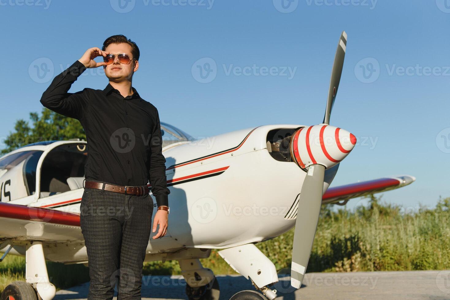 Business man with his airplanes. He is walking in the airport with the smart phone and making a call. photo