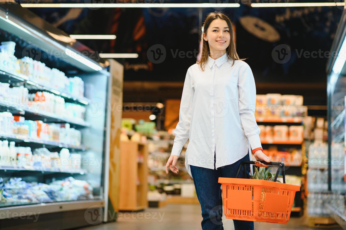 Casual woman grocery shopping and looking happy photo