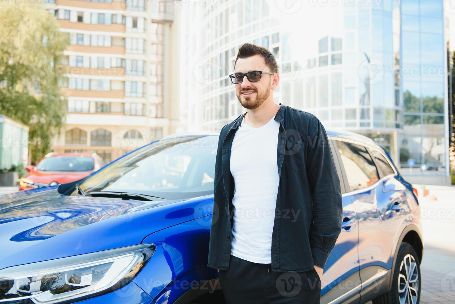 Handsome young man in standing near car outdoors photo