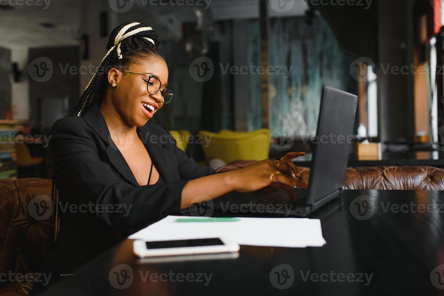 Young African American woman siting at cafe working on laptop photo