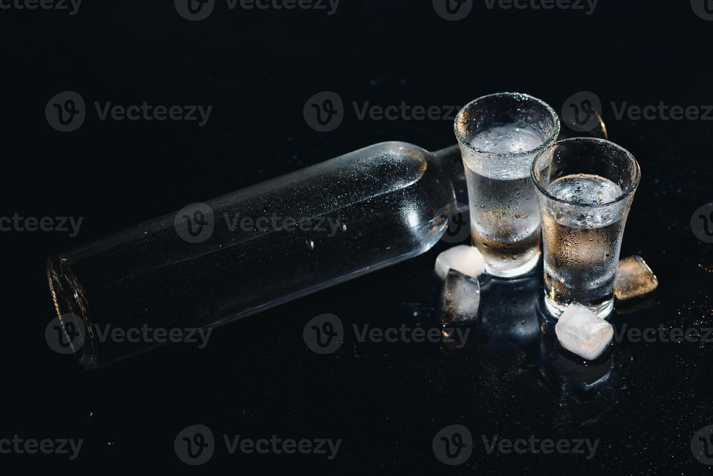 Vodka. Shots, glasses with vodka with ice .Dark background. Copy space .Selective focus. photo