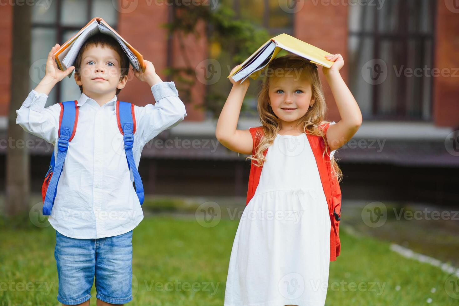 Happy children go back to school. Pupil of primary school go study with backpack outdoors. Kids go hand in hand. Beginning of lessons. First day of fall. Boy and girl from elementary student. photo