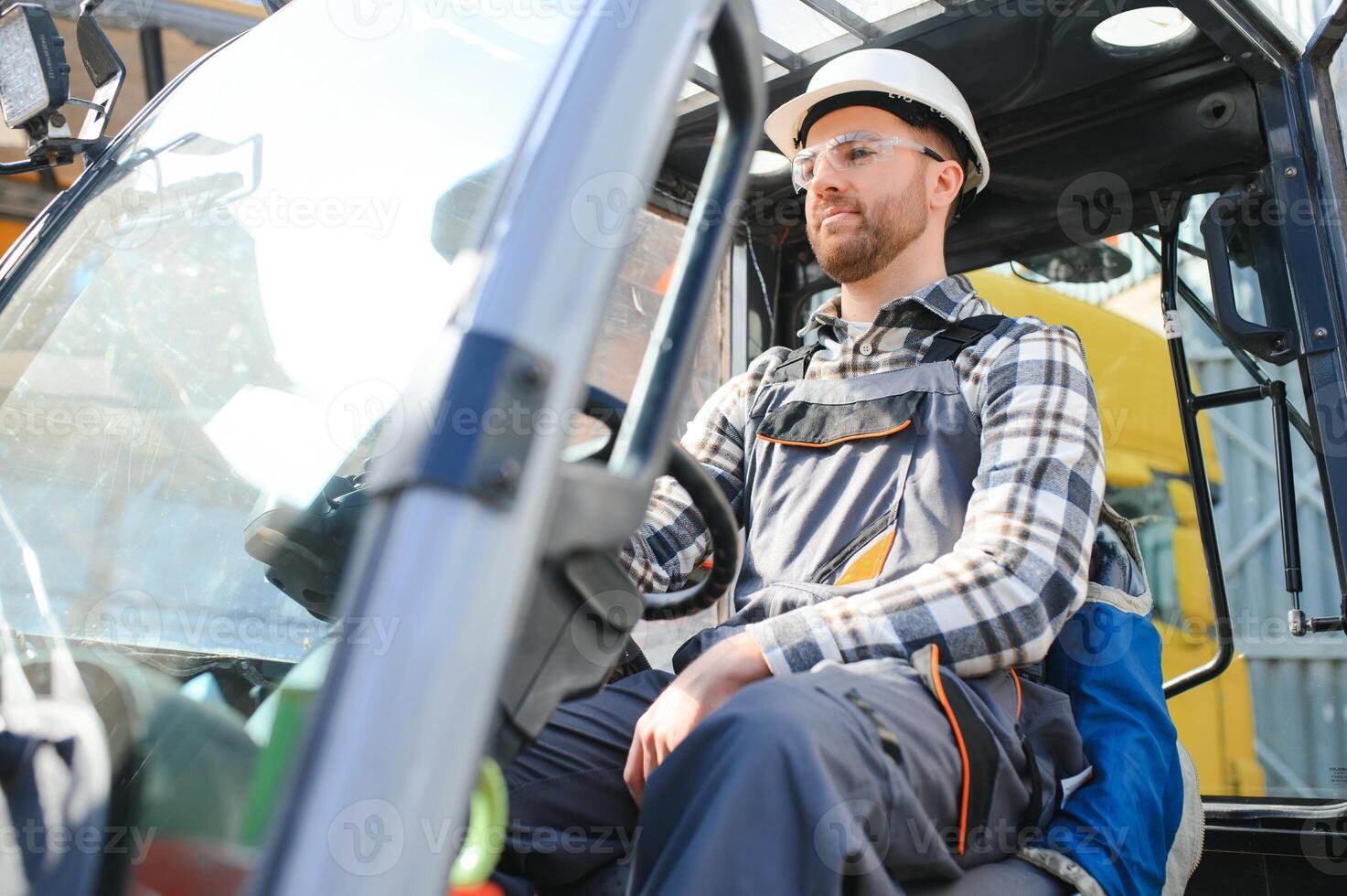 Portrait of professional forklift driver in factory's warehouse photo