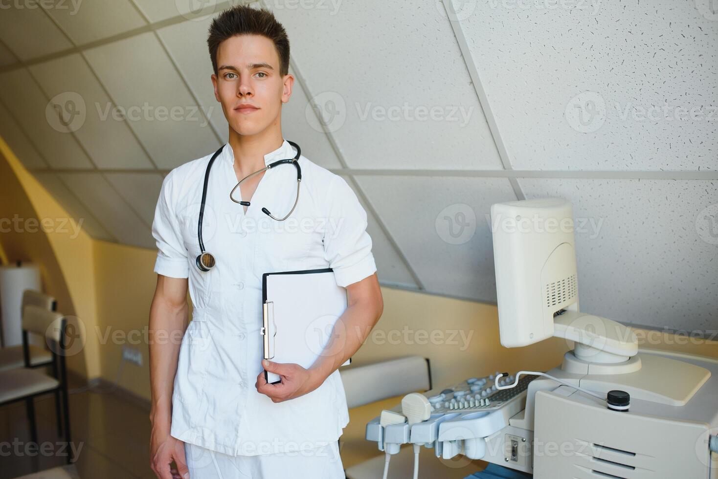 Portrait of young male technician operating ultrasound machine photo