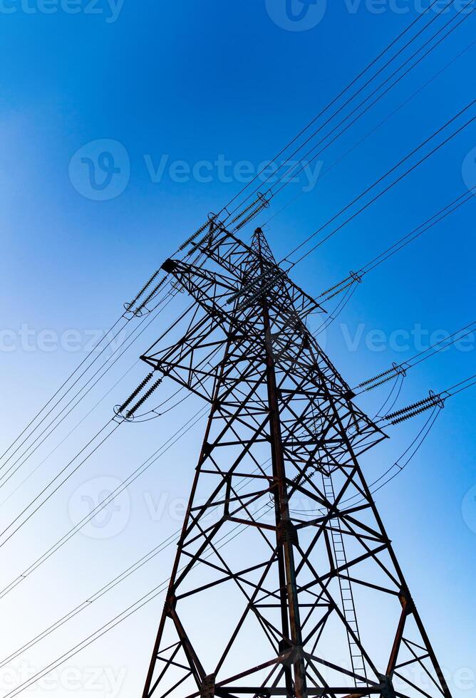 Dark silhouette of electric wire construction. Energy technologies tower shadows. photo