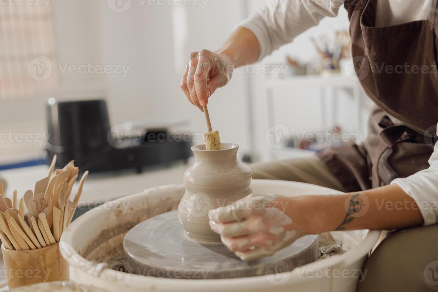 Close up of artisan's hands shaping clay bowl in pottery studio. Pottery art and creativity photo