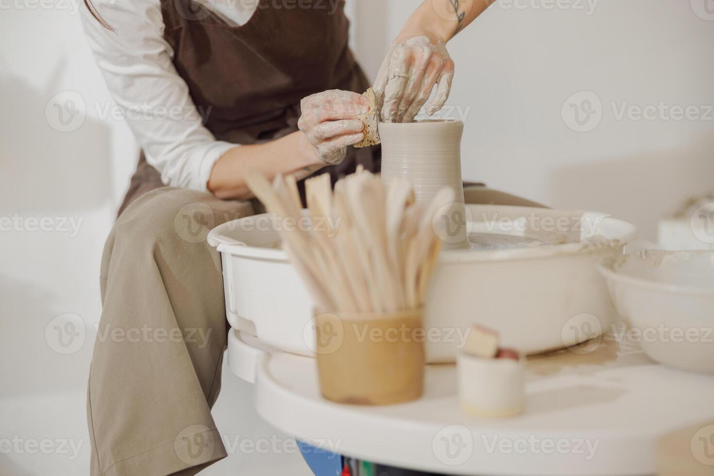 cerca arriba de manos de profesional alfarero moldura maceta forma en cerámica rueda. cerámica Arte concepto foto