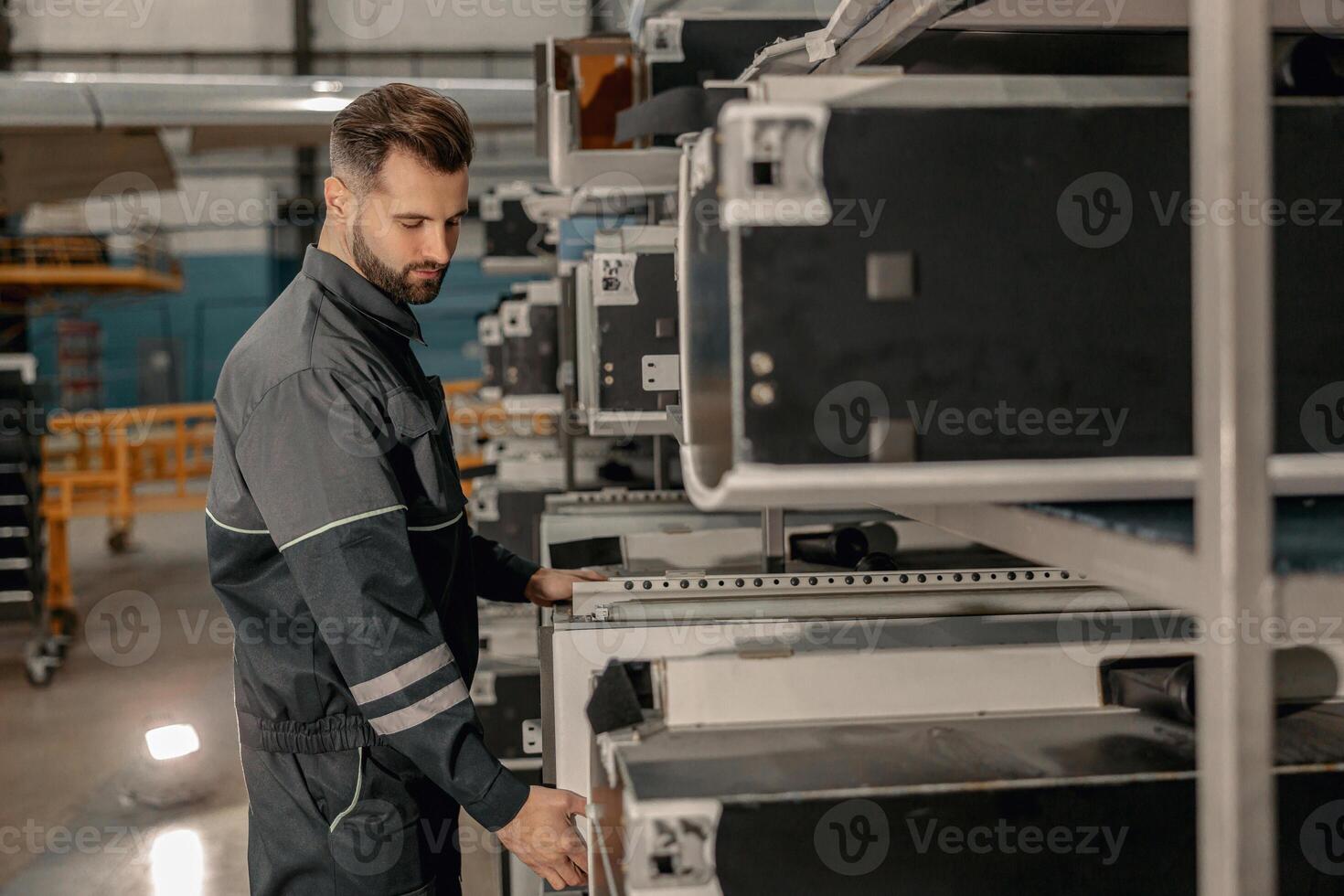 Bearded man aviation mechanic working in hangar photo