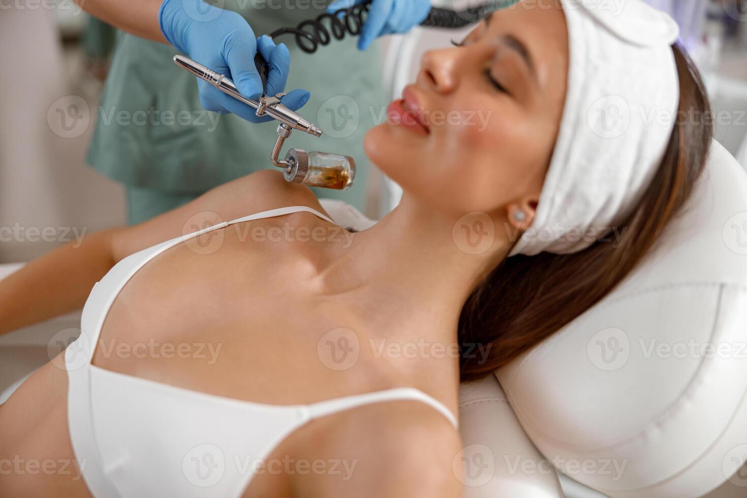 Professional female cosmetologist perform a hydrafacial procedure in a cosmetology clinic photo