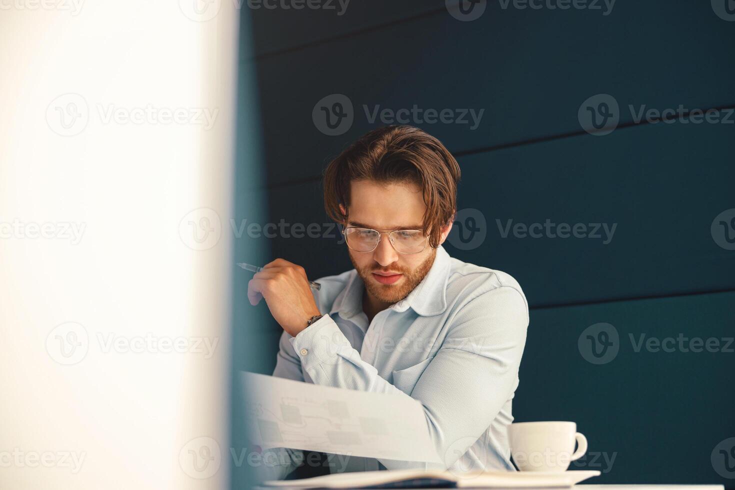 Male accountant working with financial statement during working day in office photo