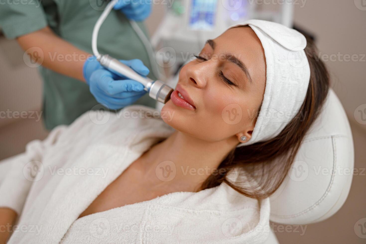 Female client getting aesthetic facial skin treatment in beauty salon photo