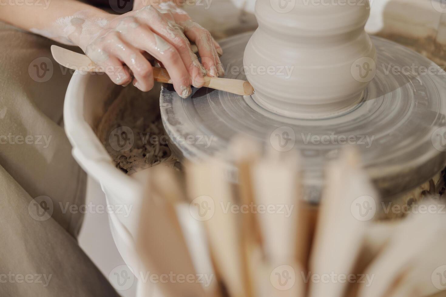 Close up of artisan's hands shaping clay bowl in pottery studio. Pottery art and creativity photo