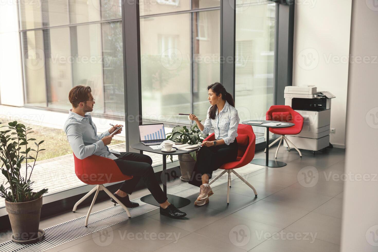 Two business colleagues analysts working with documents together sitting in office. Teamwork concept photo
