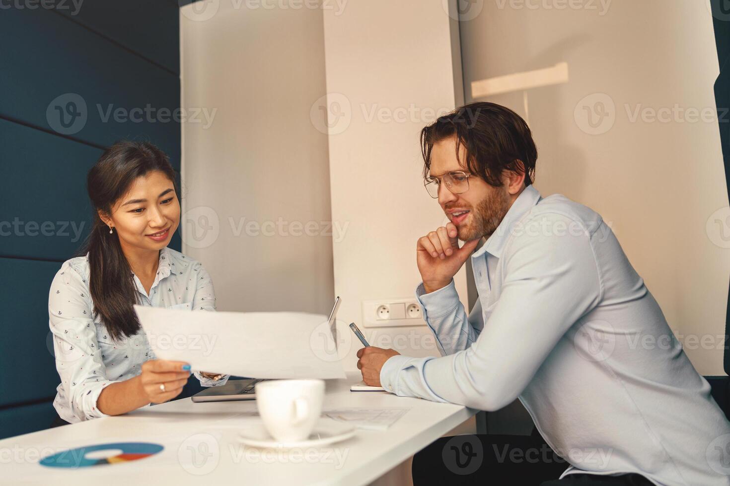 dos negocio colegas trabajando juntos con financiero declaraciones en elegante reunión habitación foto