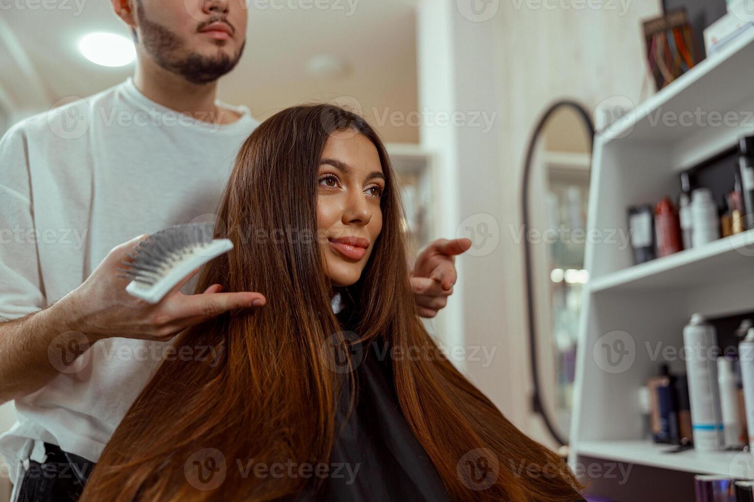 mujer mirando a sí misma en espejo satisfecho con un peinado a belleza salón foto