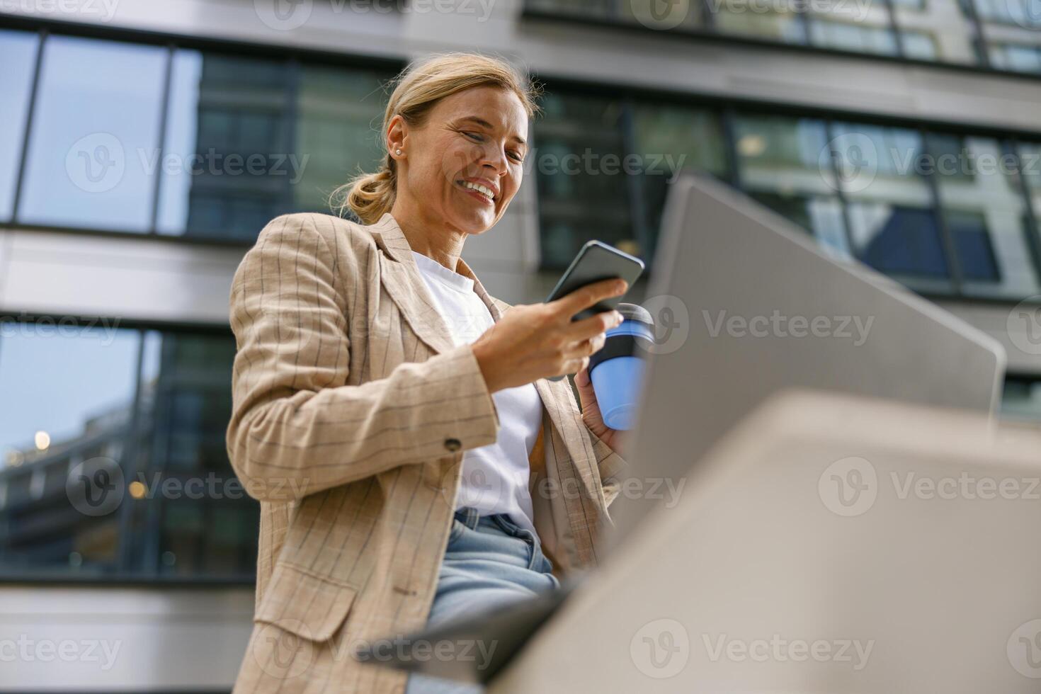 mujer de negocios es utilizando teléfono y trabajo en ordenador portátil fuera de de oficina. distancia trabajo concepto foto