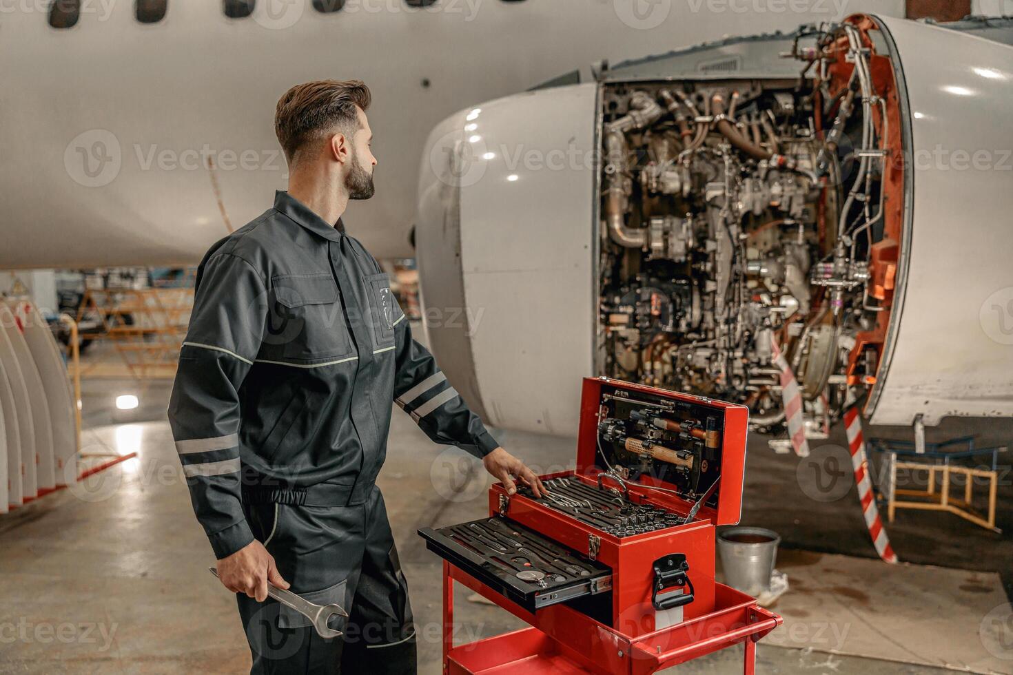 masculino aeronave mecánico utilizando herramienta caja en hangar foto