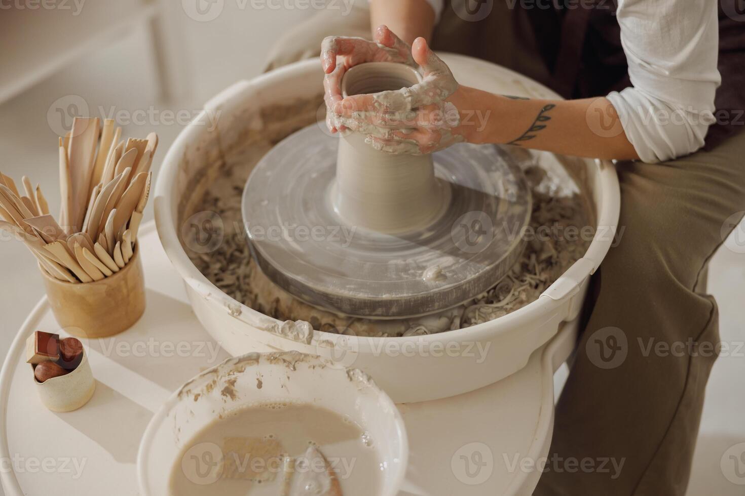 Close up of artisan's hands shaping clay bowl in pottery studio. Pottery art and creativity photo