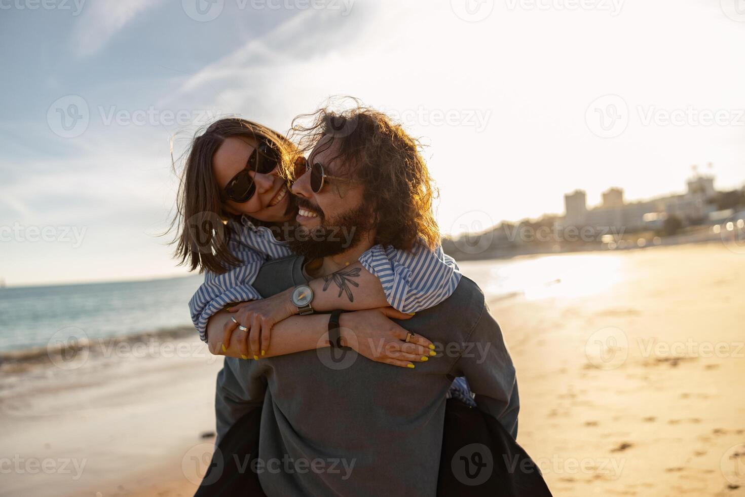 hermoso Pareja en amor abrazando mientras caminando a lo largo el playa en soleado día foto