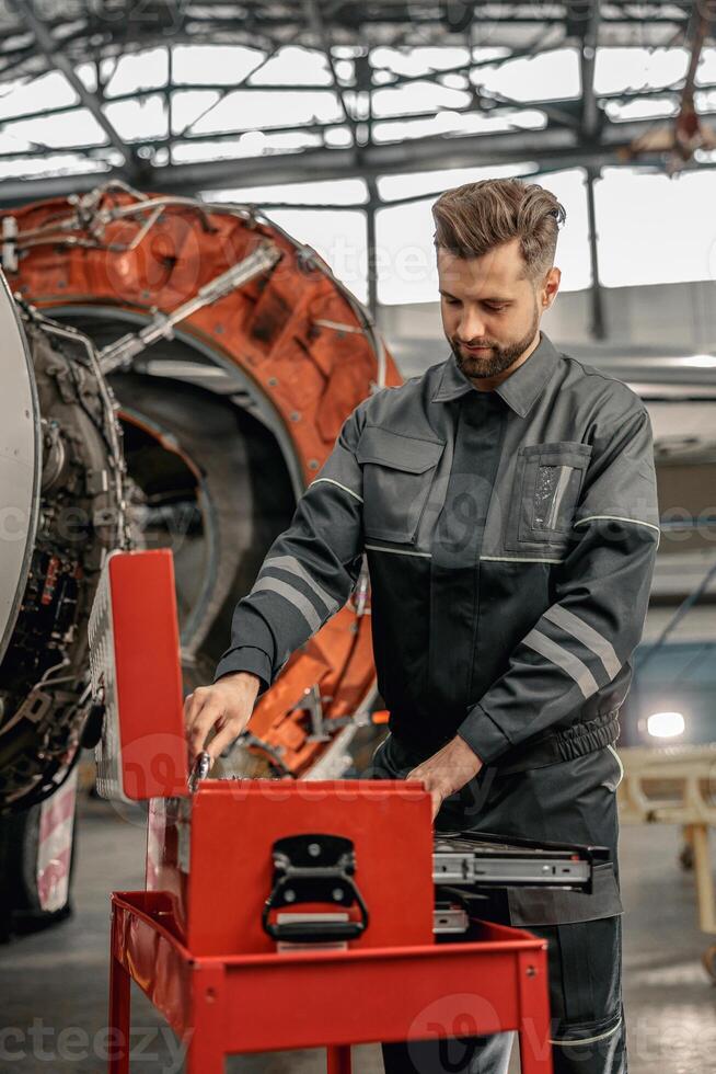 Bearded man aircraft mechanic working in hangar photo