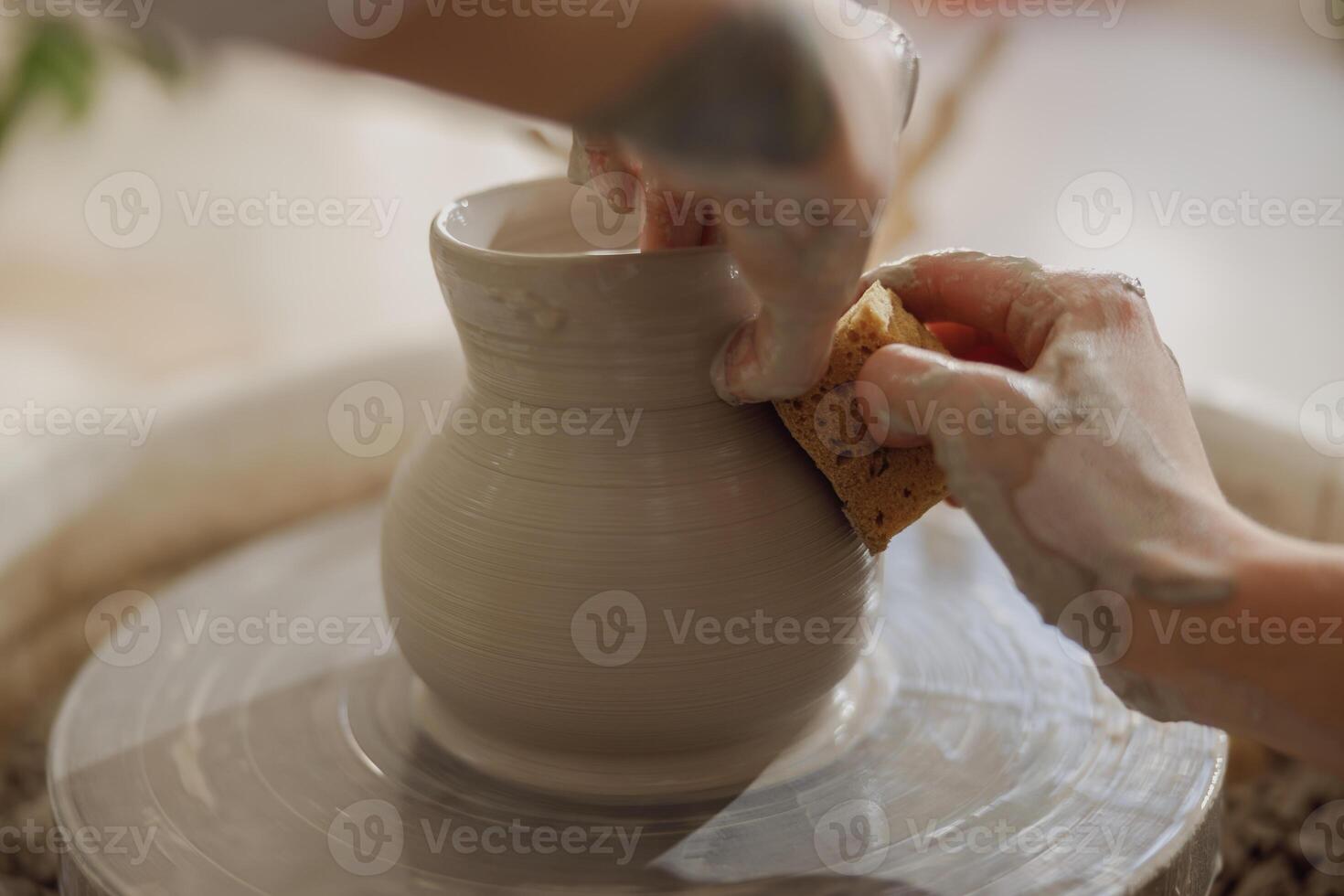 cerca arriba de manos de profesional alfarero moldura maceta forma en cerámica rueda. cerámica Arte concepto foto