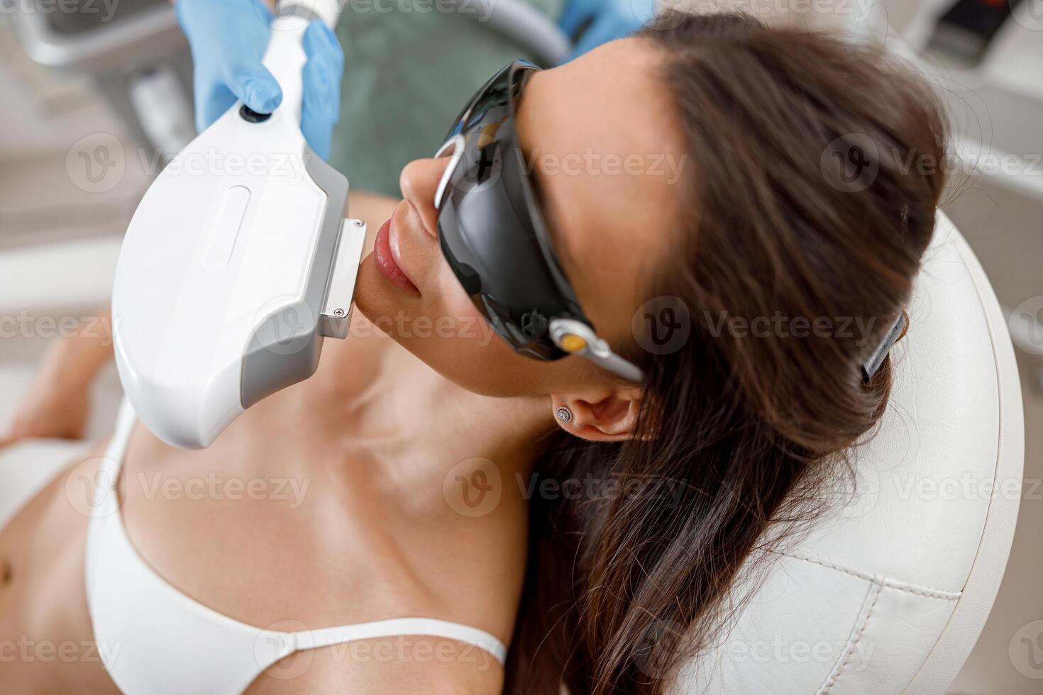 Portrait of female client getting aesthetic face treatment in beauty salon photo