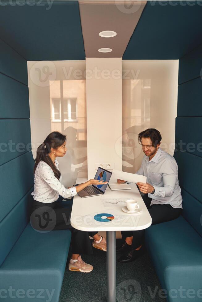 Two business colleagues working together with financial statements in stylish coworking photo