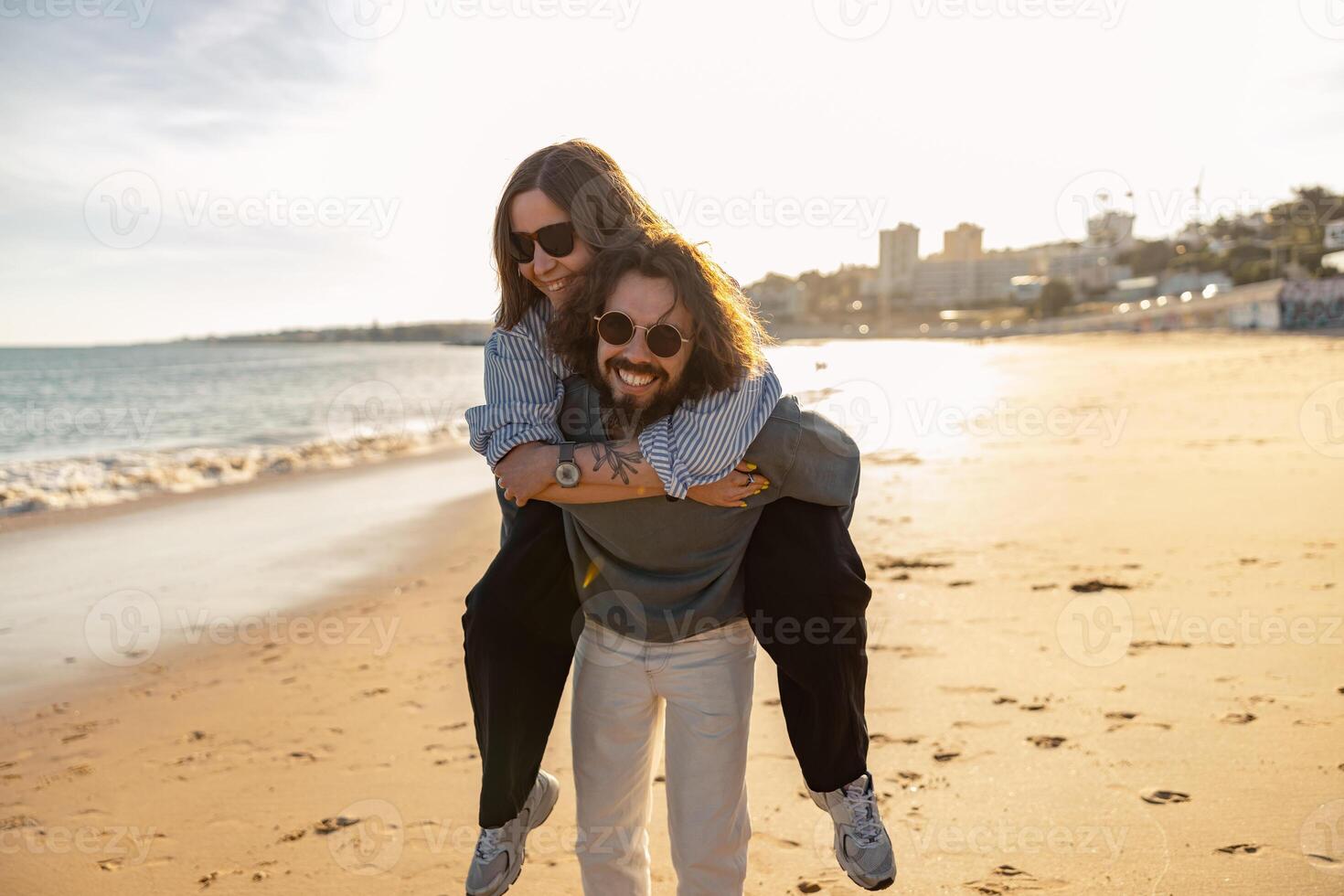 hermoso Pareja en amor abrazando mientras caminando a lo largo el playa en soleado día foto